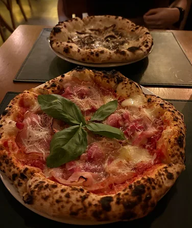 Artisanal pizza with basil and cured meat